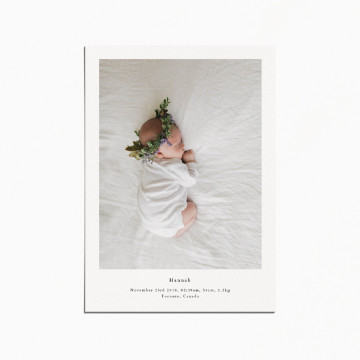 birth announcement card with an image of a baby sleeping and wearing a flower crown