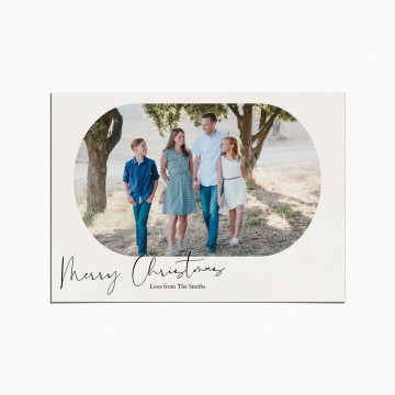 Holiday Card with an image of a family smiling as they stand outdoors in a grove. The title reads "Merry Christmas"
