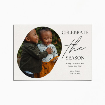 Holiday Card with an image of of two toddlers embracing. The title reads "Celebrate the Season"