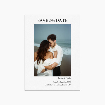Save the date wedding invitation card featuring "Save the Date" written in uppercase and an image of two people embracing on a beach. Beneath the image are wedding details
