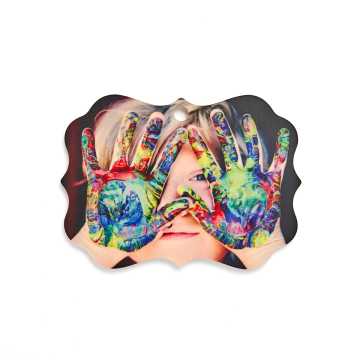 Wooden ornament with an image of child with paint on her hands
