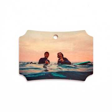 Wooden ornament with an image of two surfers in the ocean