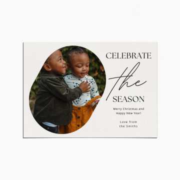 Holiday Card with an image of of two toddlers embracing. The title reads "Celebrate the Season"