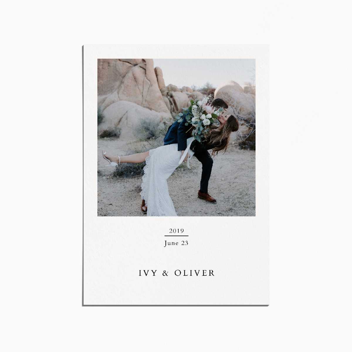 card with an image of a couple on their wedding day, the bride is being dipped. they are in a rocky desert landscape