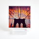 a small plexi tabletop stand holding up a card with an image of Brooklyn bridge at sunset
