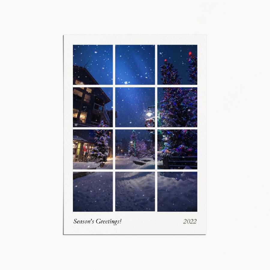 Holiday card with a grid image depicting a christmas village in the evening